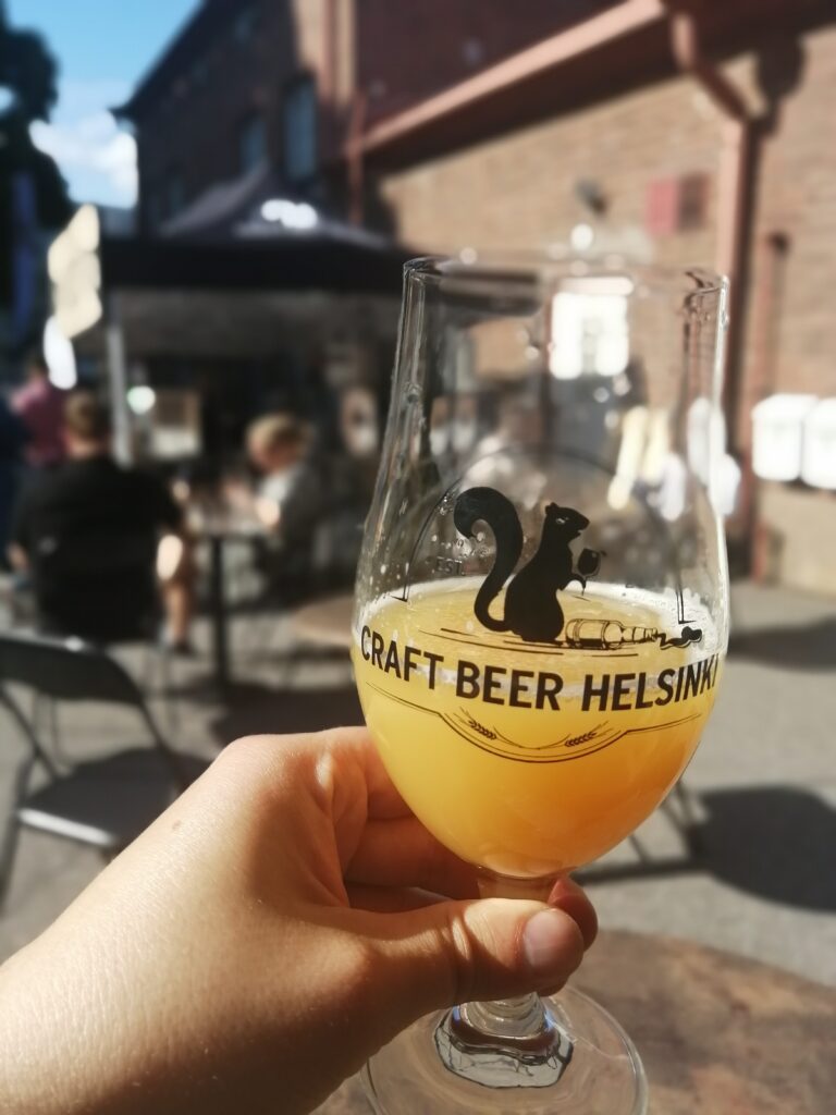 Kädessä lasi, jossa sameaa NEIPA-tyylistä olutta